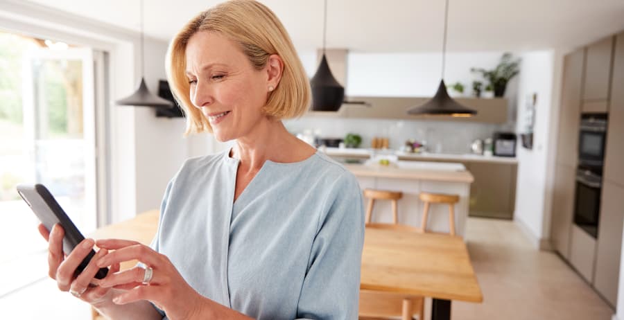 Woman with mobile device in a room filled with sunlight
